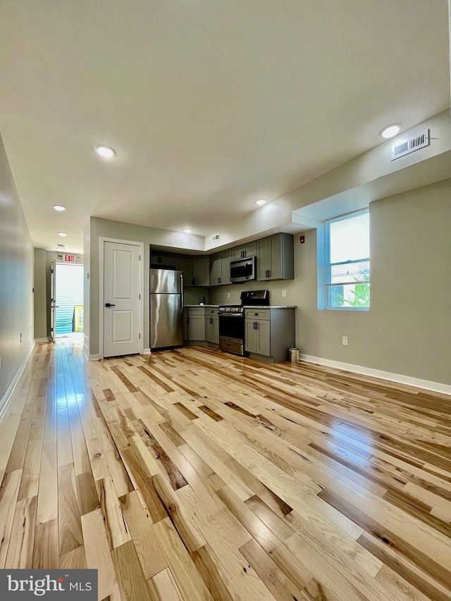 kitchen with light wood-type flooring and appliances with stainless steel finishes