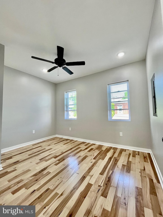 spare room featuring a wealth of natural light, ceiling fan, and light hardwood / wood-style floors