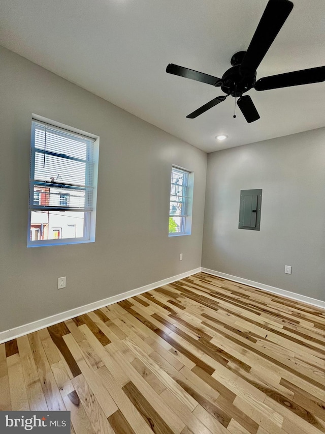 spare room with ceiling fan, light wood-type flooring, and electric panel