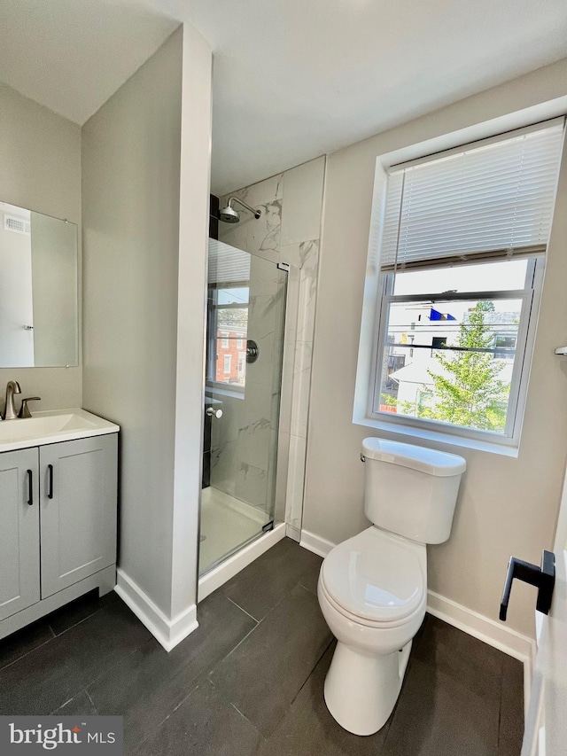 bathroom featuring tile patterned floors, vanity, toilet, and an enclosed shower