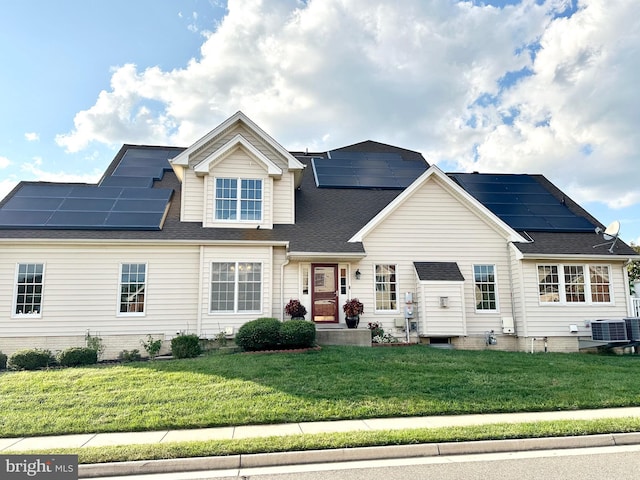 view of front facade with central AC unit, a front yard, and solar panels