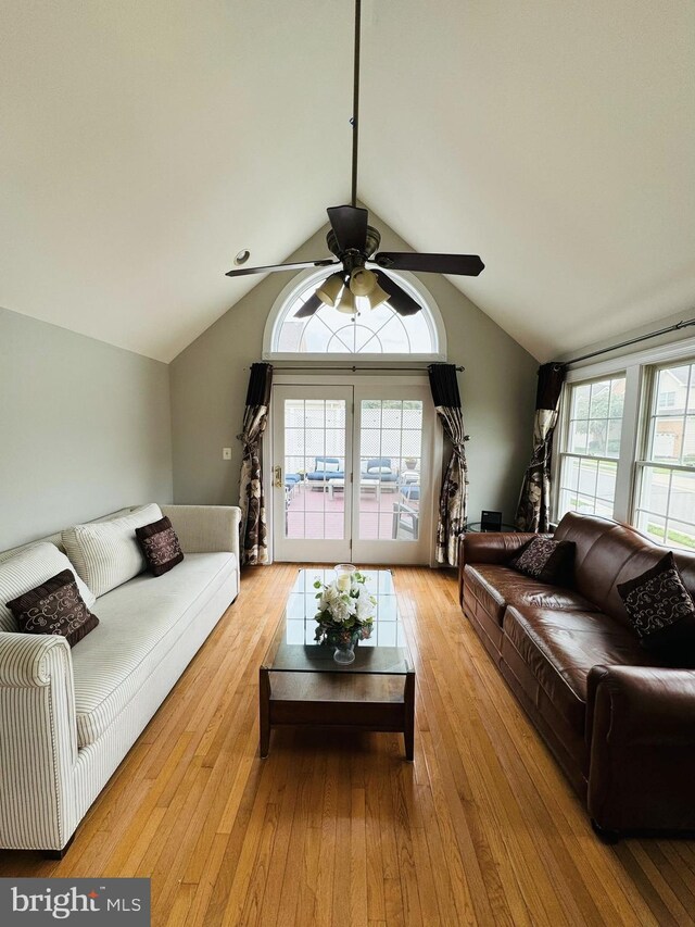 living room featuring ceiling fan, light wood-type flooring, and vaulted ceiling