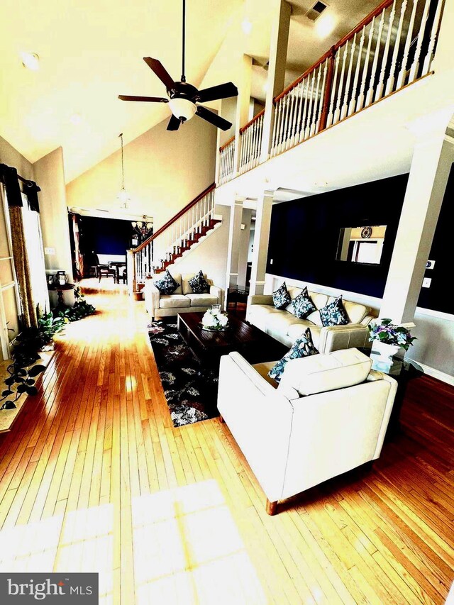 living room featuring hardwood / wood-style floors, high vaulted ceiling, and ceiling fan