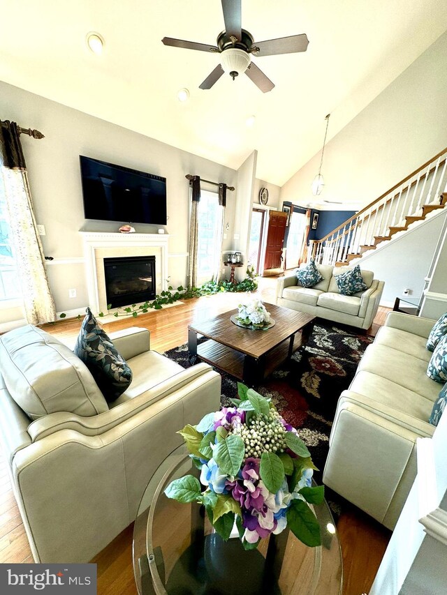 living room featuring hardwood / wood-style flooring, ceiling fan, and lofted ceiling