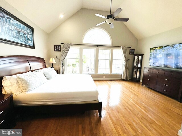 bedroom with high vaulted ceiling, light hardwood / wood-style flooring, and ceiling fan