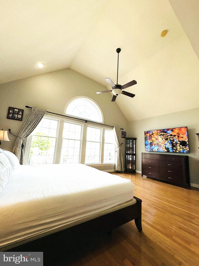 bedroom with hardwood / wood-style flooring, vaulted ceiling, and ceiling fan