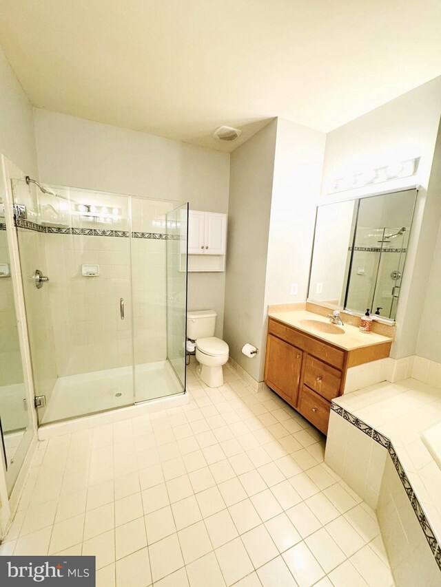 bathroom with toilet, tile patterned flooring, vanity, and walk in shower