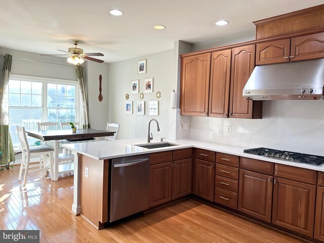 kitchen featuring dishwasher, sink, ceiling fan, kitchen peninsula, and gas cooktop