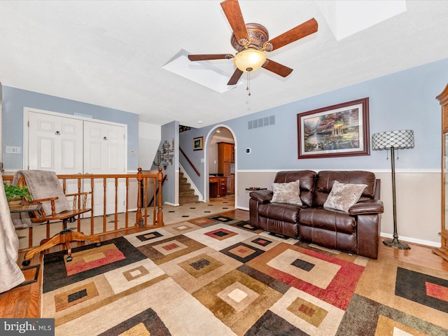 living room with a textured ceiling and ceiling fan