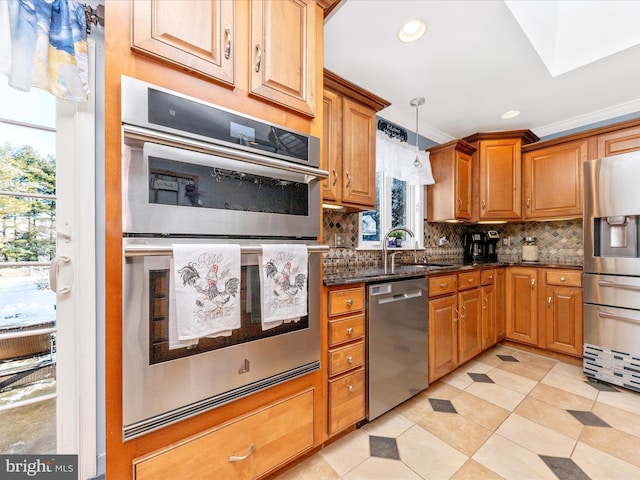 kitchen with plenty of natural light, backsplash, appliances with stainless steel finishes, and dark stone countertops