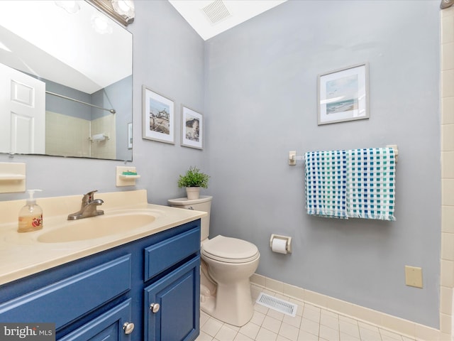 bathroom featuring toilet, vanity, tile patterned flooring, and a shower