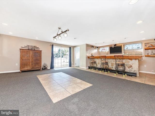 unfurnished living room featuring bar and carpet floors