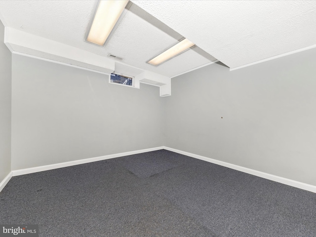 unfurnished room with a textured ceiling and carpet flooring