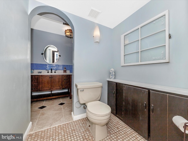 bathroom with decorative backsplash, tile patterned floors, vanity, and toilet