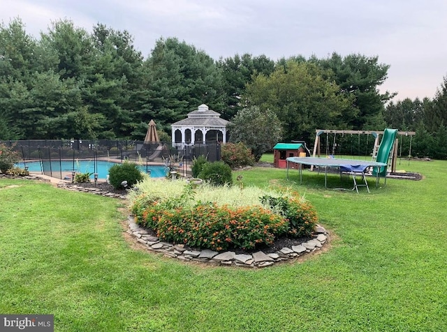 view of yard with a playground, a gazebo, a community pool, and a trampoline