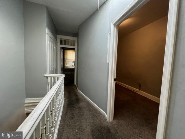 corridor with dark colored carpet