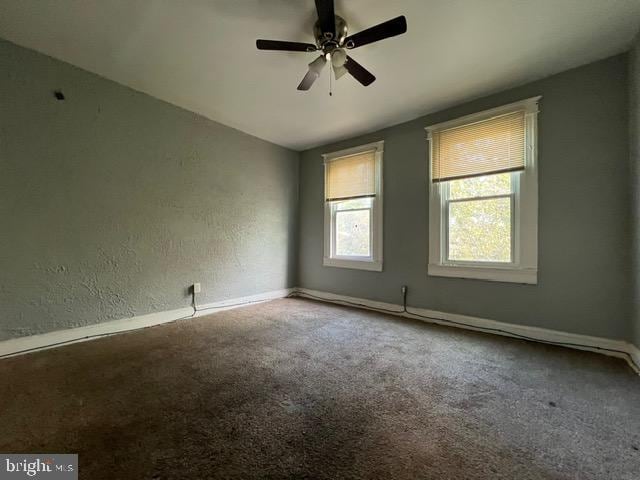 carpeted spare room with ceiling fan