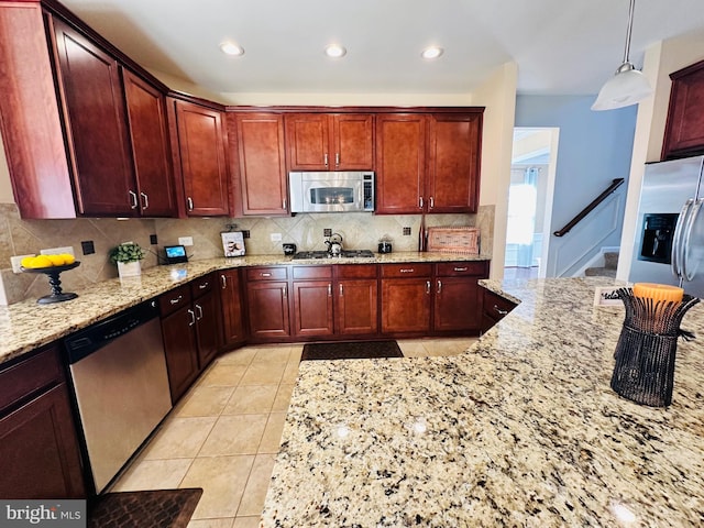 kitchen featuring light tile patterned flooring, decorative light fixtures, tasteful backsplash, stainless steel appliances, and light stone countertops