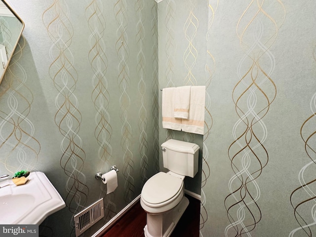 bathroom with wood-type flooring and toilet