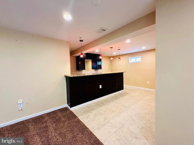 kitchen featuring light stone counters and kitchen peninsula