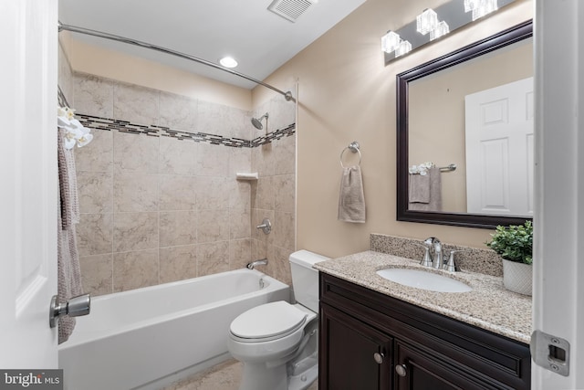 full bathroom featuring vanity, tiled shower / bath, and toilet