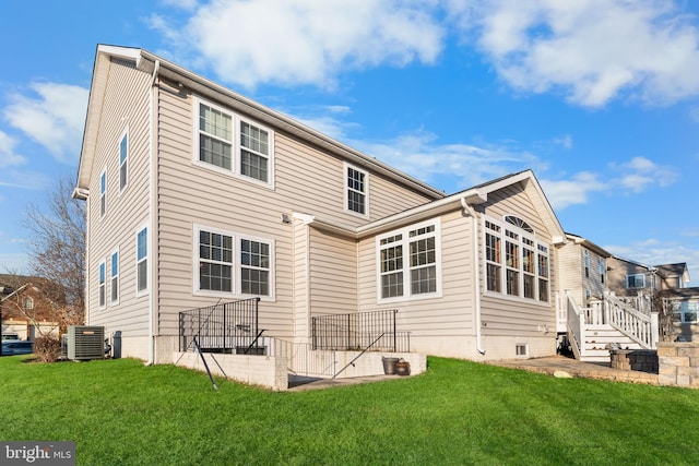 back of property with central AC unit and a lawn