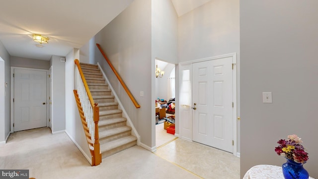 carpeted foyer featuring an inviting chandelier