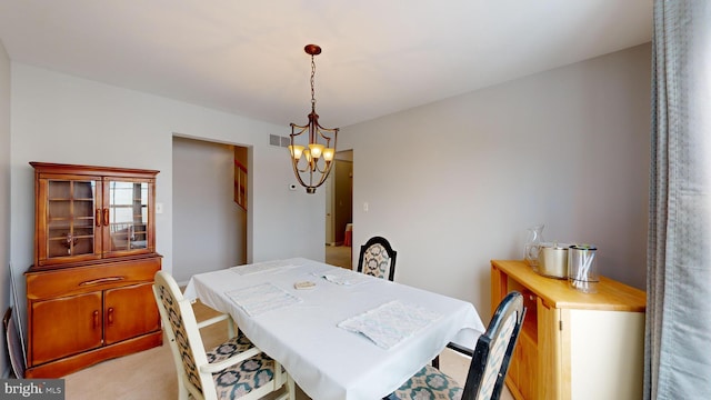 carpeted dining area featuring a chandelier