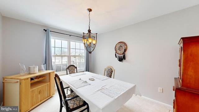 dining space featuring light carpet and a notable chandelier