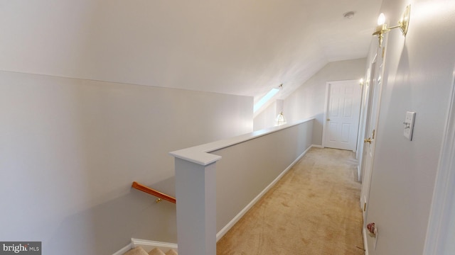 corridor with light colored carpet and lofted ceiling