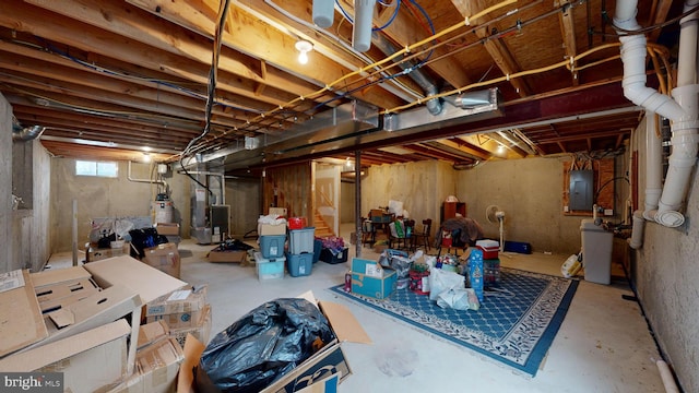 basement featuring heating unit, electric panel, and water heater