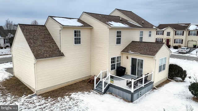 view of snow covered rear of property