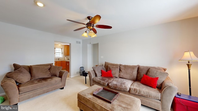 carpeted living room featuring sink and ceiling fan