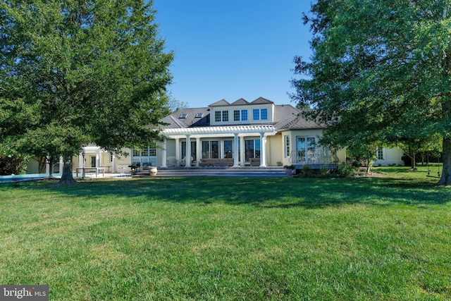 rear view of house featuring a pergola and a yard