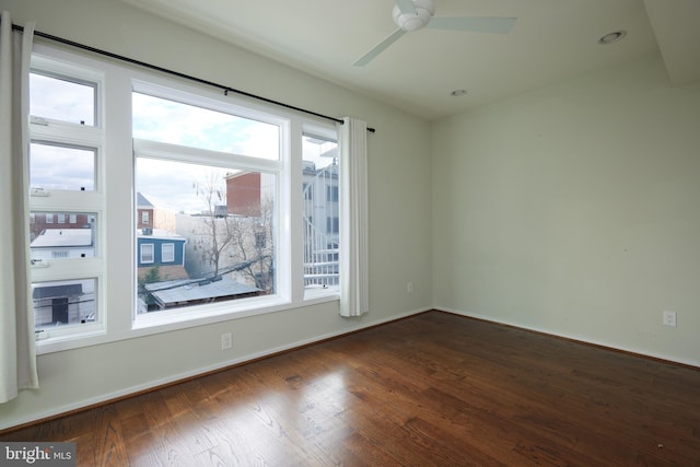 empty room with ceiling fan and dark hardwood / wood-style flooring