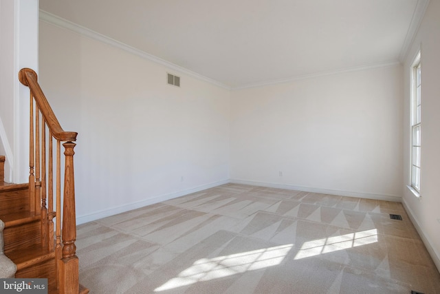 spare room featuring light carpet, baseboards, visible vents, stairs, and crown molding