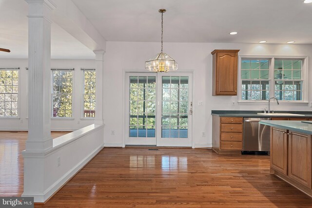 kitchen with decorative columns, brown cabinets, dishwasher, and wood finished floors