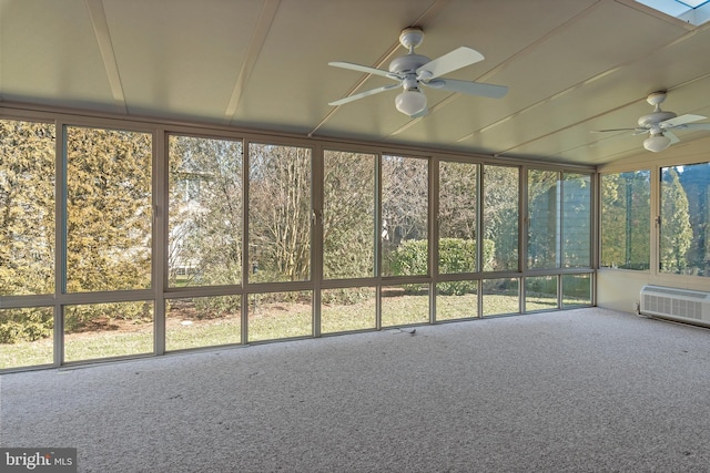 unfurnished sunroom featuring ceiling fan and a wall mounted AC