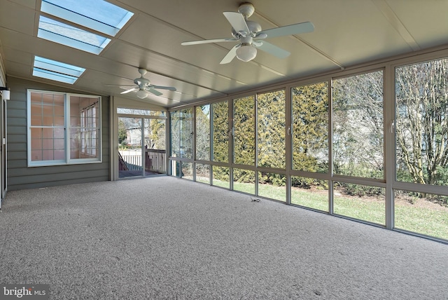 unfurnished sunroom featuring vaulted ceiling with skylight and a ceiling fan