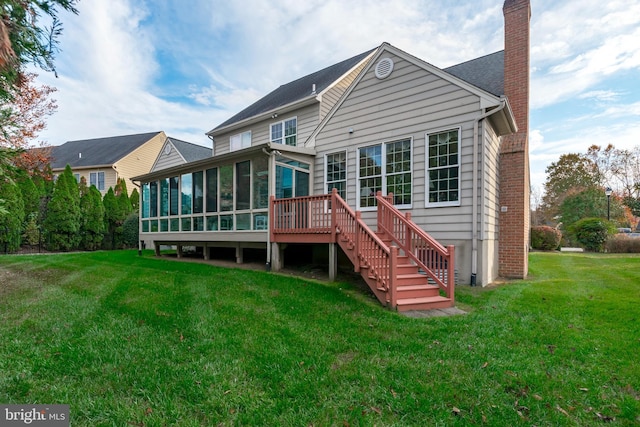 rear view of property with stairway, a sunroom, a yard, and a chimney