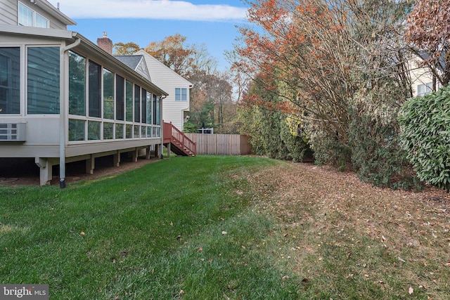 view of yard featuring a sunroom and fence