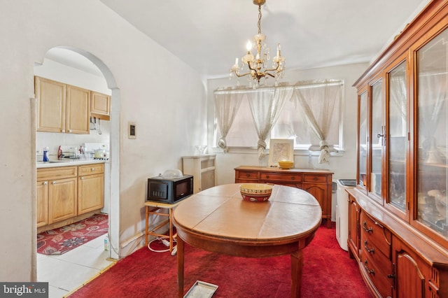 tiled dining room featuring an inviting chandelier