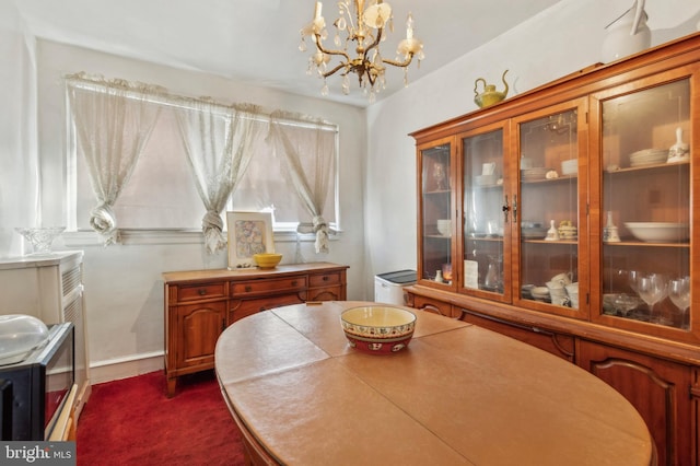 carpeted dining area featuring a notable chandelier