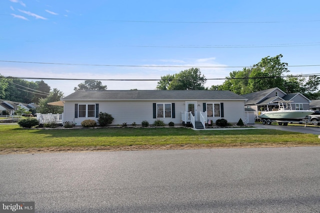 ranch-style house with a garage, an outbuilding, and a front yard