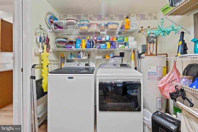 washroom with washing machine and dryer and water heater