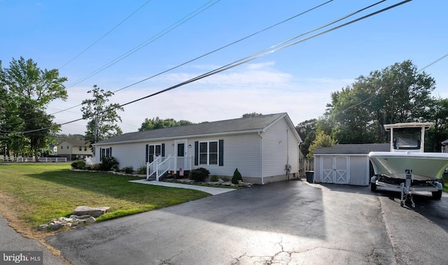 view of front of property with a front lawn and a shed