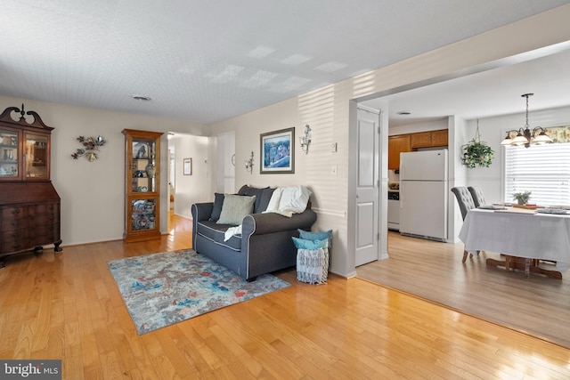 living room featuring light hardwood / wood-style floors and an inviting chandelier