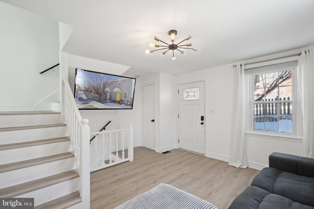 living room with an inviting chandelier and light hardwood / wood-style floors