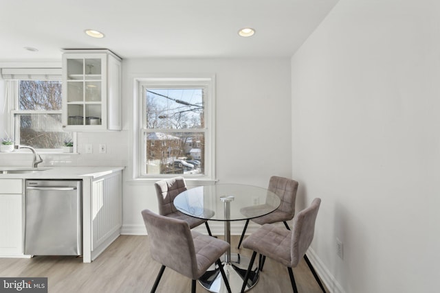 dining room featuring light wood-type flooring, a wealth of natural light, and sink