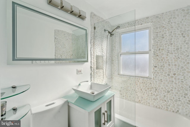 full bathroom with toilet, tiled shower / bath, and vanity